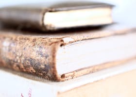 Stack of old books with worn covers, emphasizing vintage charm and literary history.