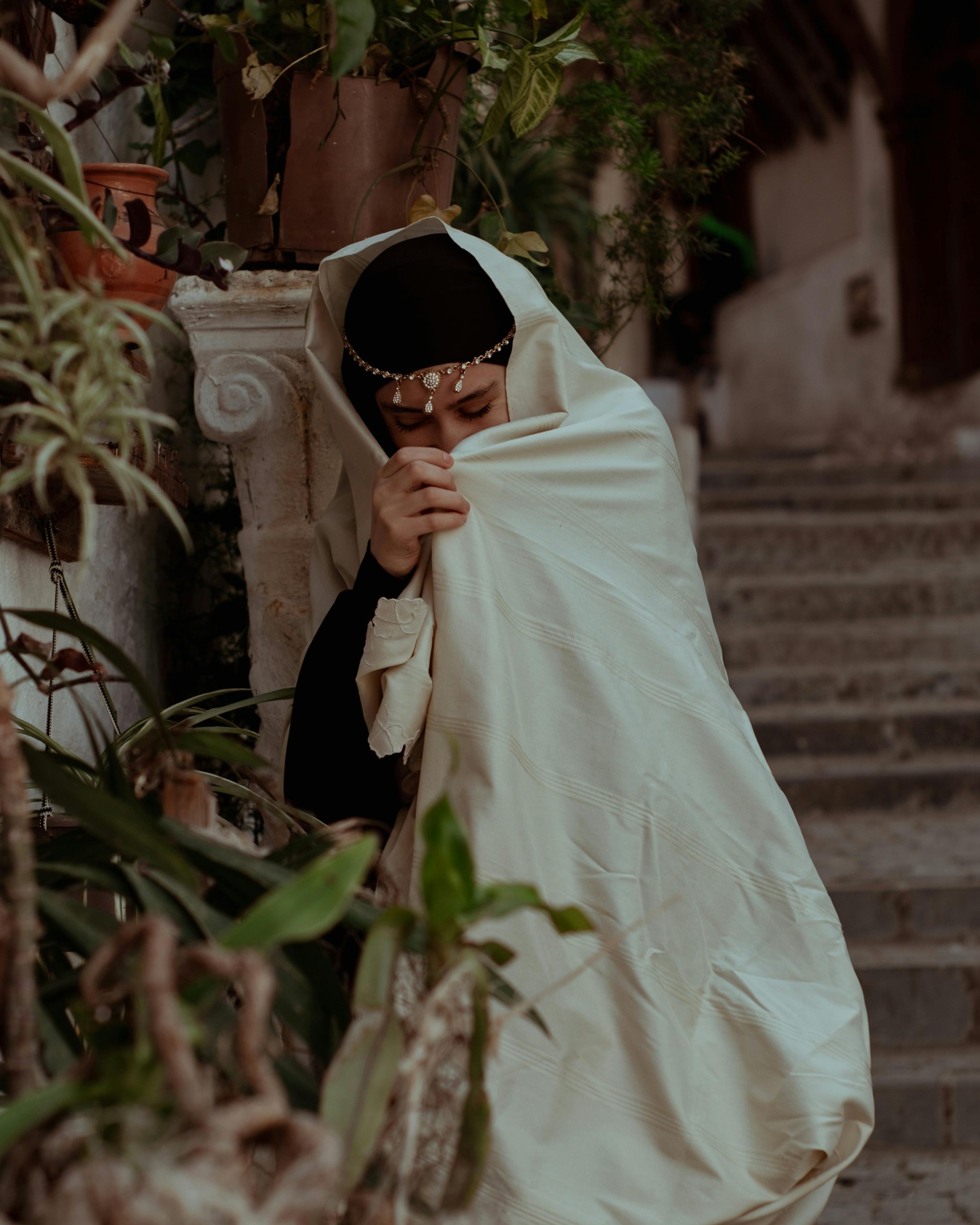 Young woman in traditional attire with hijab, in the historic Casbah, Algiers.